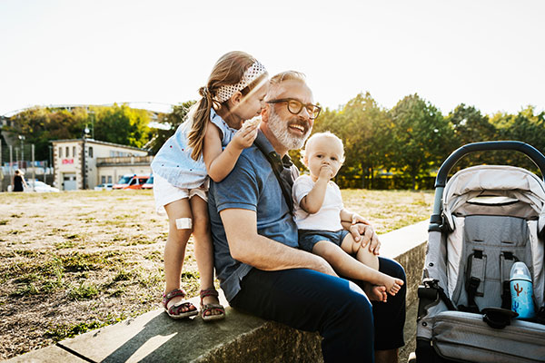 photo of white father and two children laughing at park